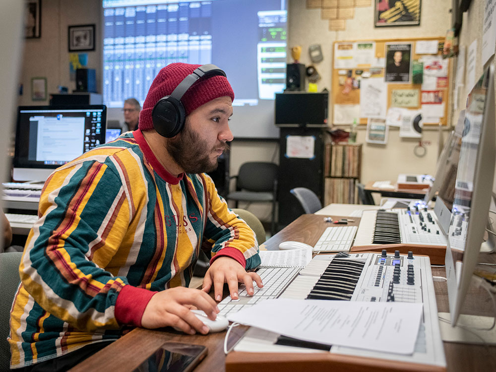 Student using musical technology to produce.