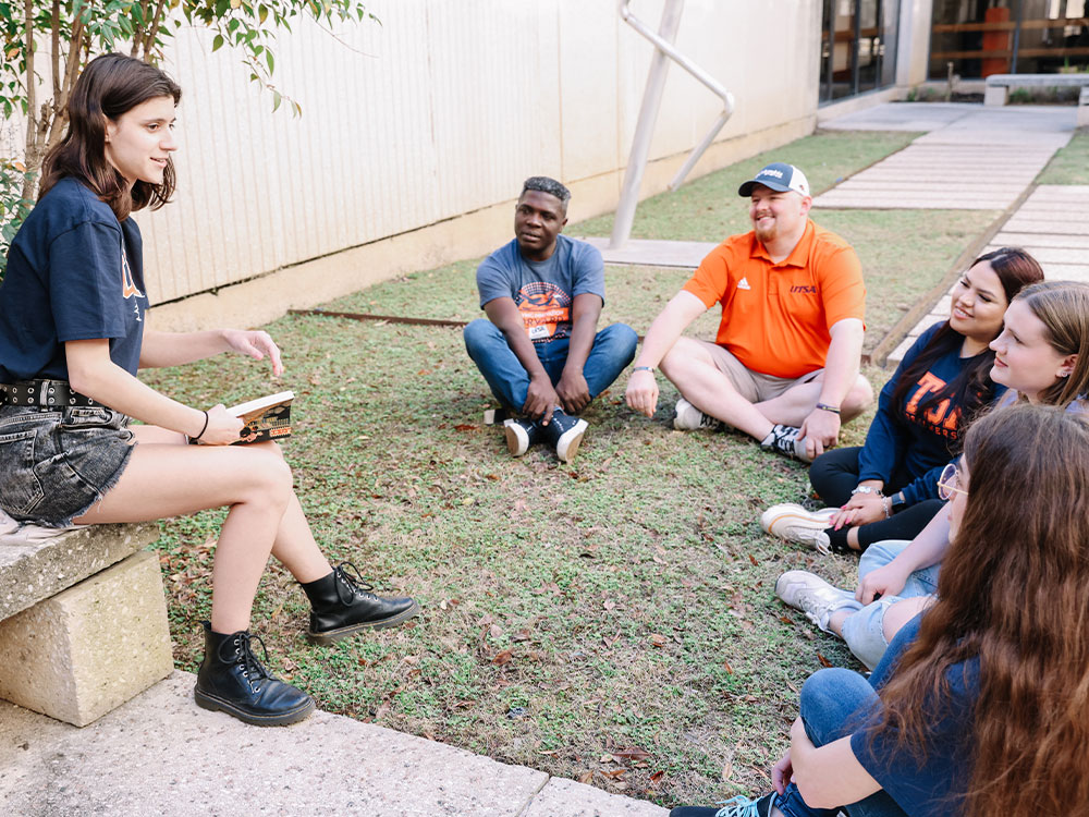 A group of UTSA students engaging in open discussion about literature.