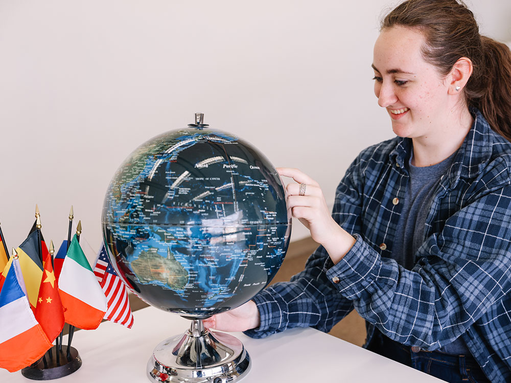 UTSA student examining a globe.