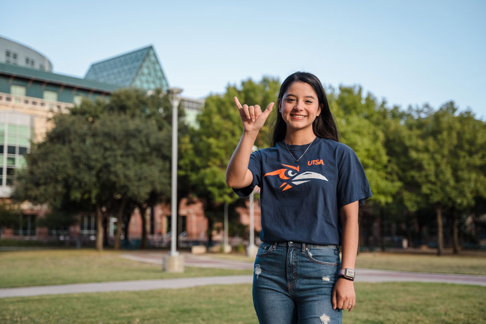 UTSA student showing the hand sign birds up