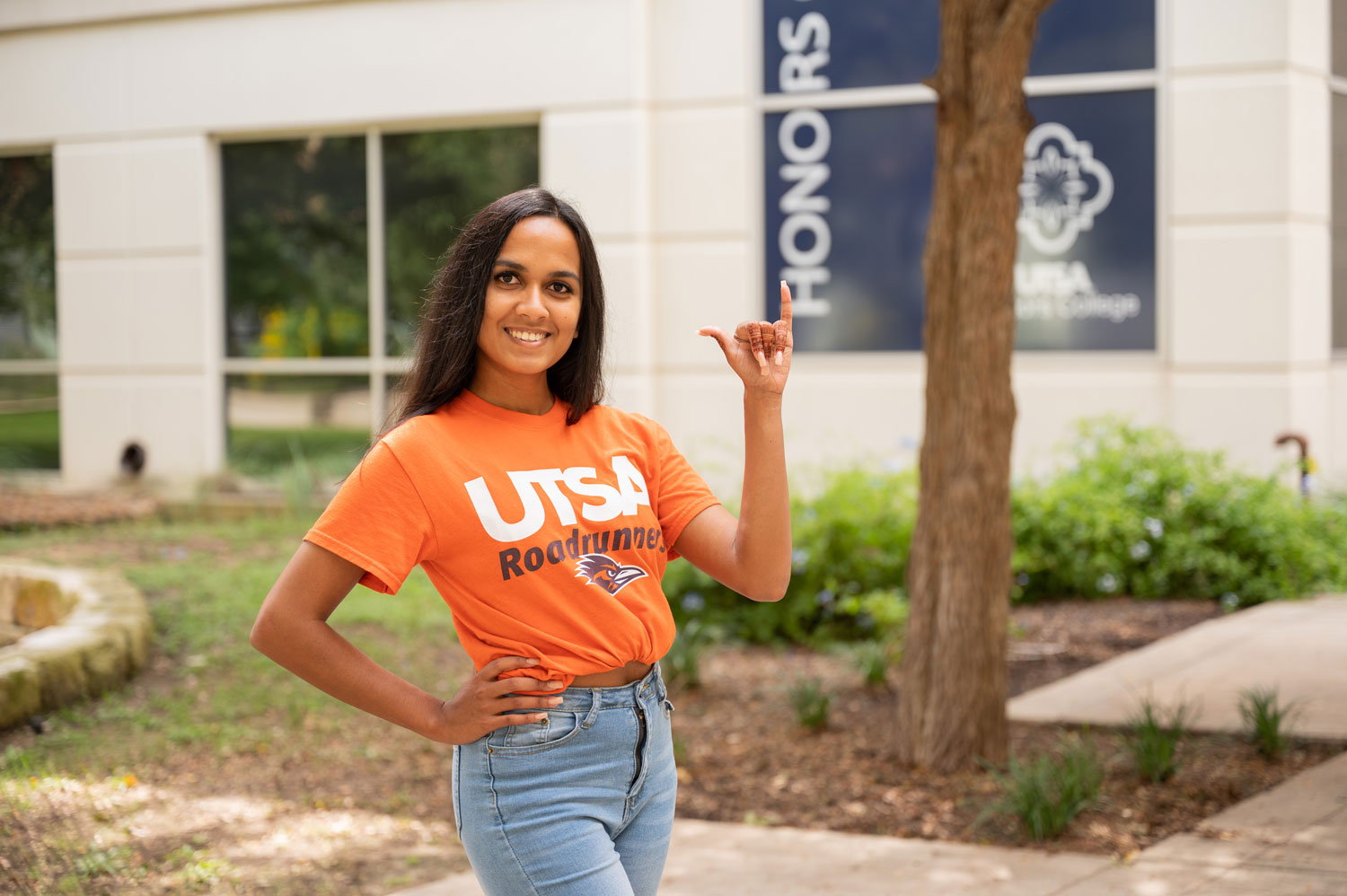 UTSA student with the hand signal birds up
