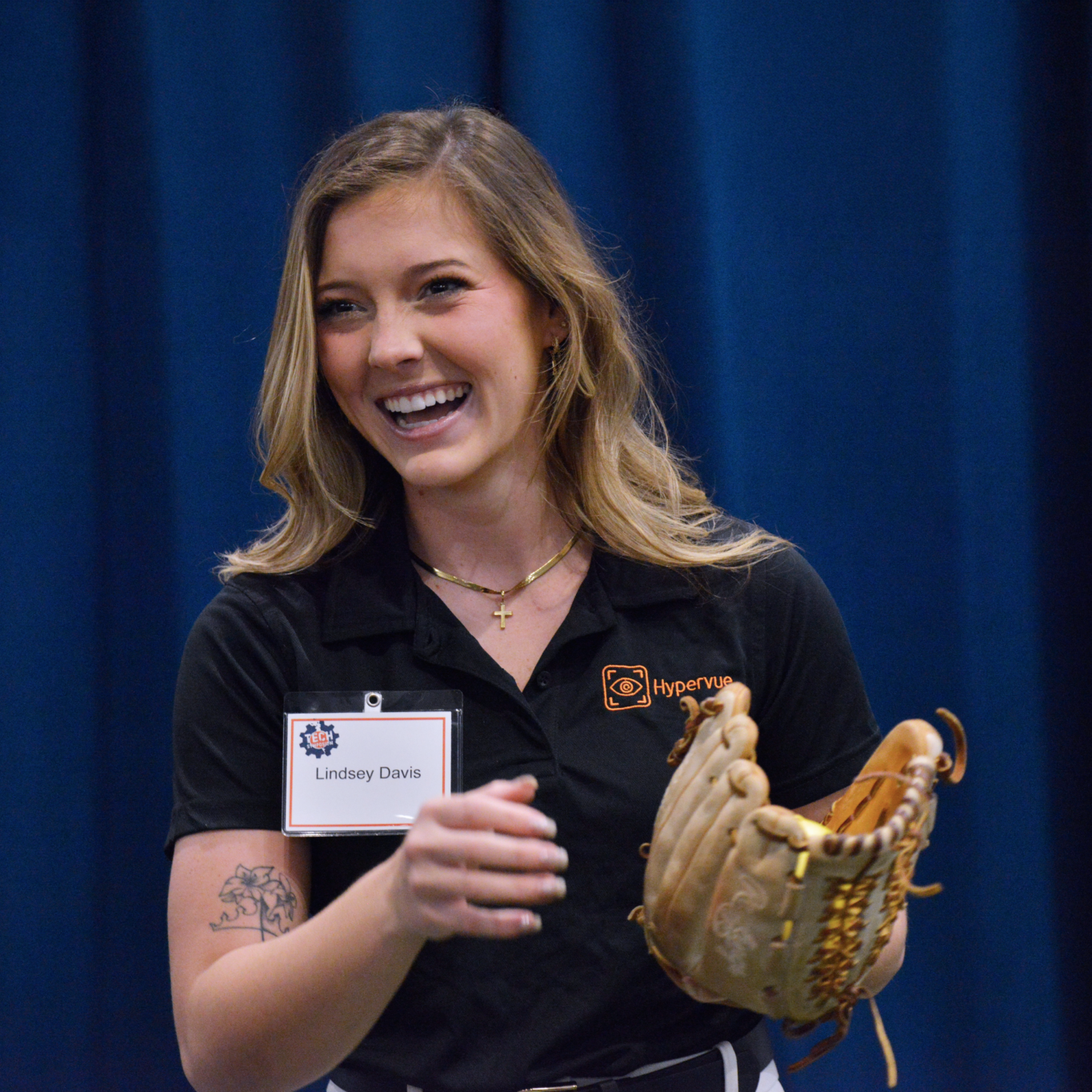 Lindsey Davis at Tech Symposium posing with softball and catcher's mitt.