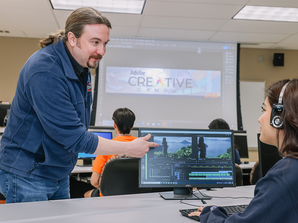 Faculty member guiding a student through video edits in Adobe Premiere