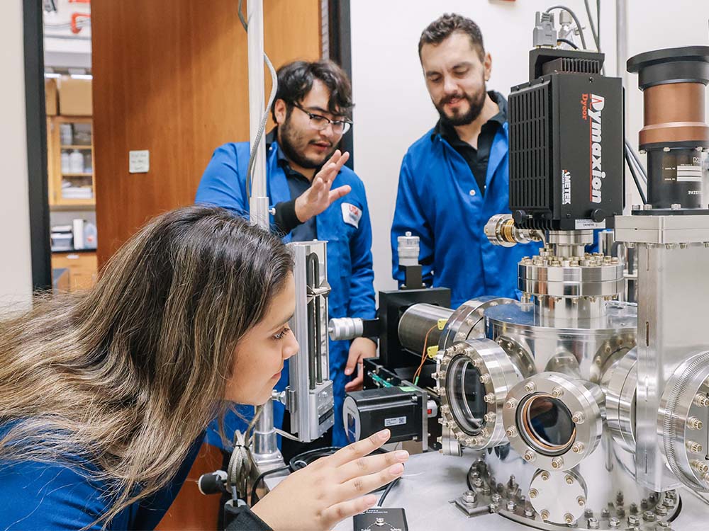A faculty member and students in a corrosion lab