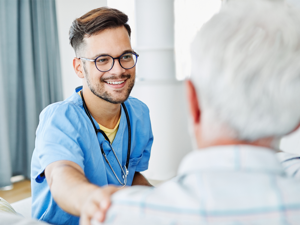 Male nurse comforting elderly patient