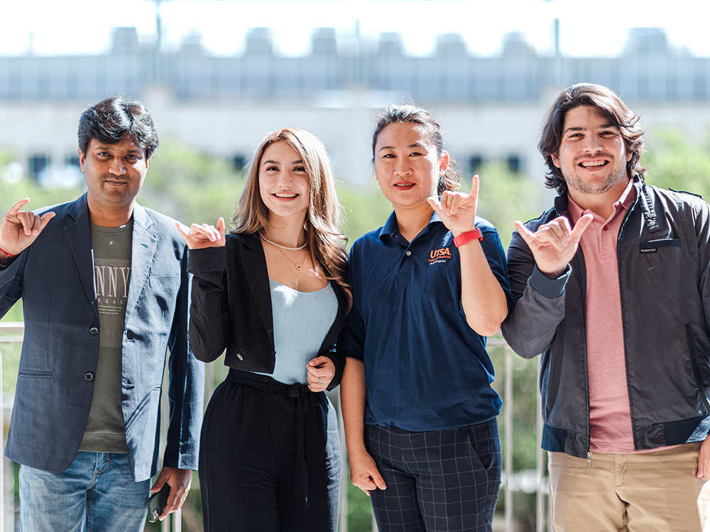 A diverse group of business students throwing a birds up.