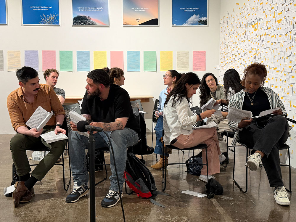 A group of students sitting in an art gallery.