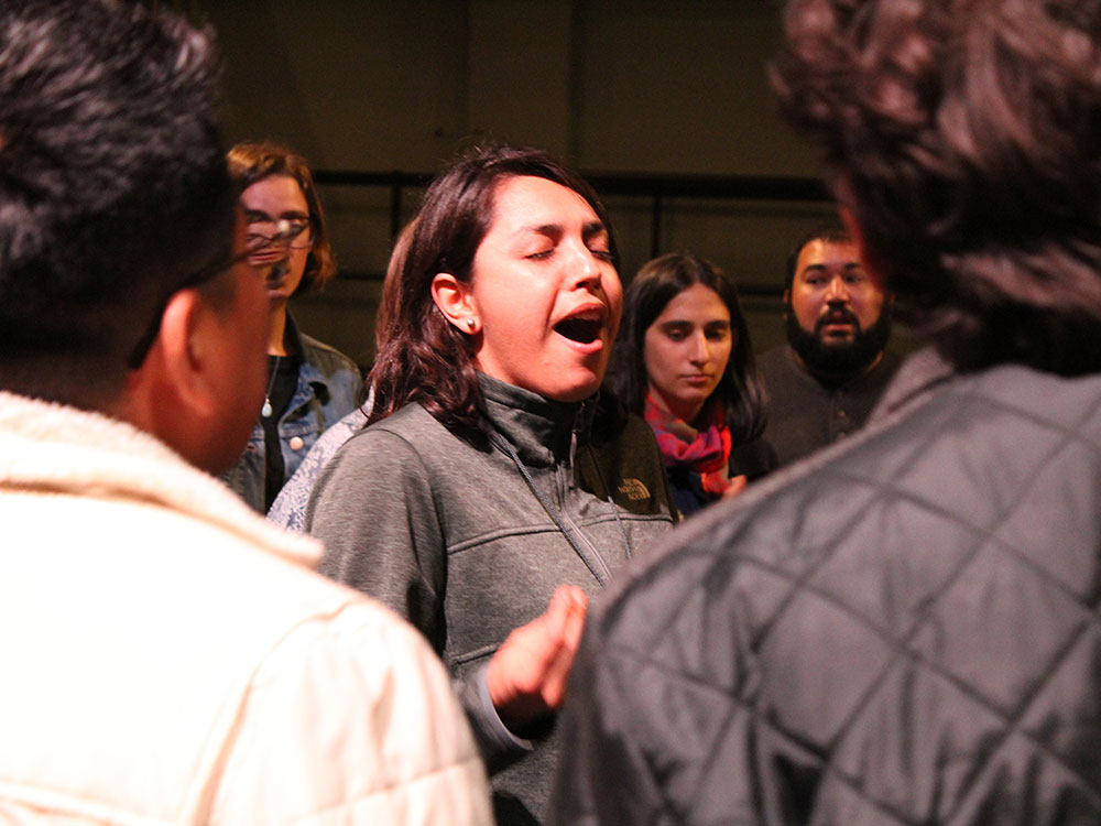 A group of students singing backstage.