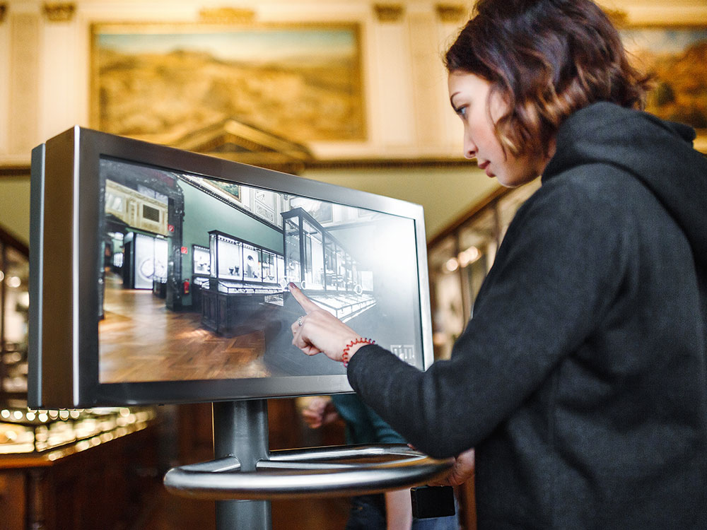 Woman swiping through a digital screen in a museum.