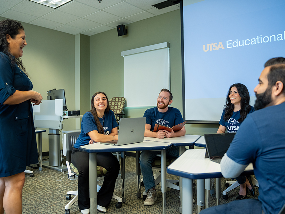 Professer having a discussion with a group of engaged students.