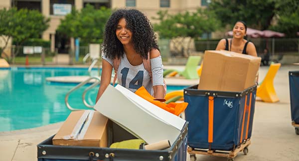 Student and family moving in near pool on campus