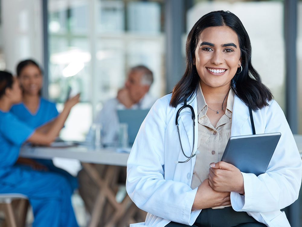 Medical doctor smiling with a clip board.