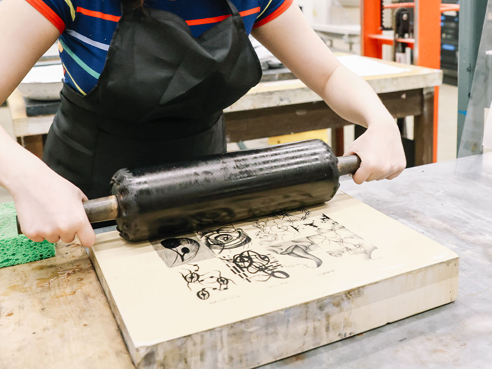 Student working with printmaking materials.