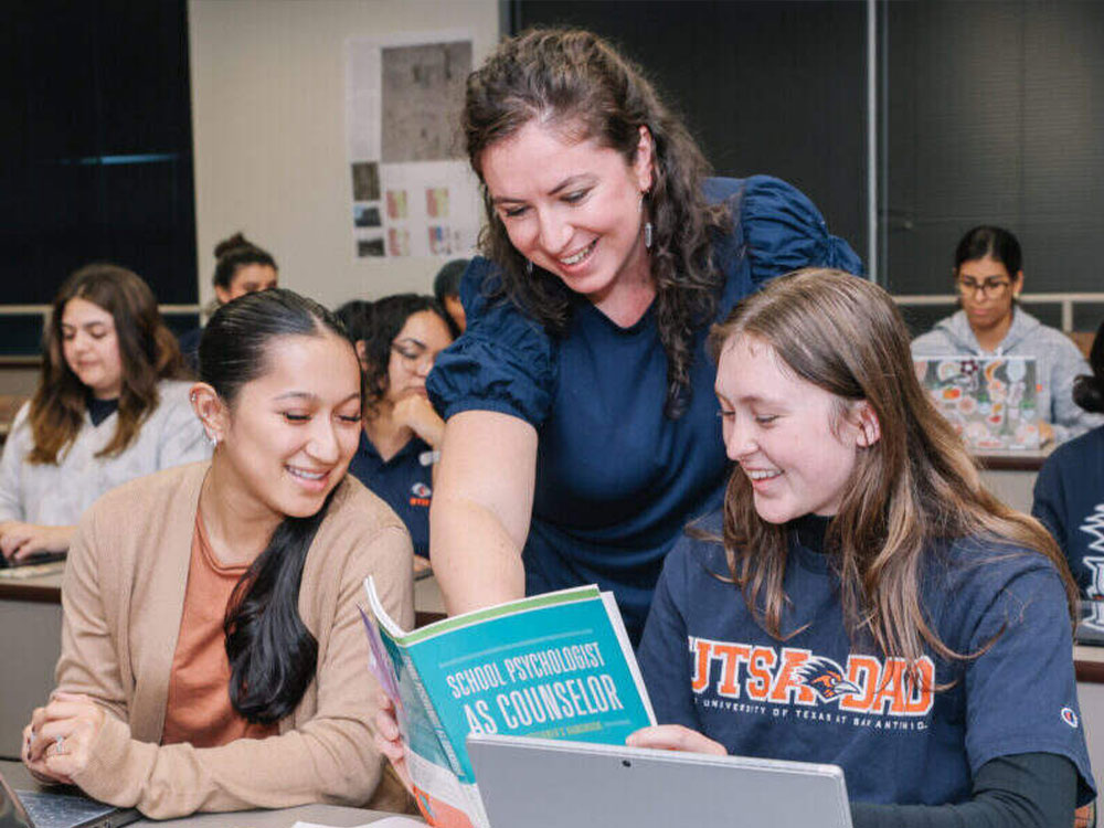 Psychology professor interacting with students in a classroom setting.